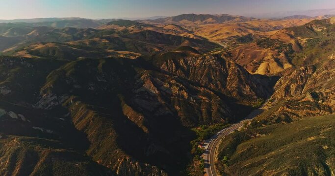 Mountainous landscape in the United States. Wavy road passing through the rocky area. Rocky panorama on clear sunny day from top view.