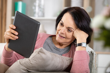 mature woman browsing the internet with a digital tablet