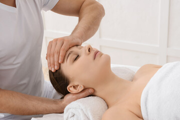 Fototapeta na wymiar Young pretty woman having head massage in spa, white background. Copy space, closeup