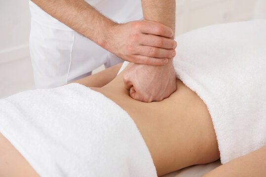 Close Up Of Osteopath Doing Manipulative Massage On Woman Abdomen On White Background, Copy Space