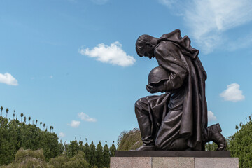 Berlin, Germany - 2022.07.30: Detail of the statue of a soldier bowing at Soviet War Memorial Treptow and military cemetery in the Treptower park.