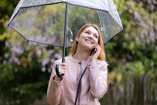 portrait of a beautiful girl with umbrella calls a friend