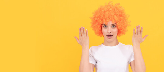 surprised freaky woman in curly clown wig with raised hands, surprise. Woman isolated face portrait, banner with copy space.