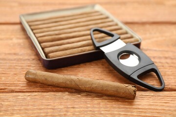 Cigars and guillotine cutter on wooden table