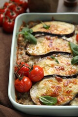 Delicious eggplant lasagna in baking dish on table, closeup