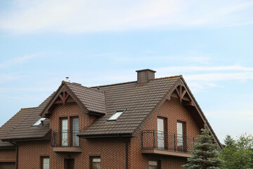 Fototapeta na wymiar Beautiful house with brown roof against blue sky