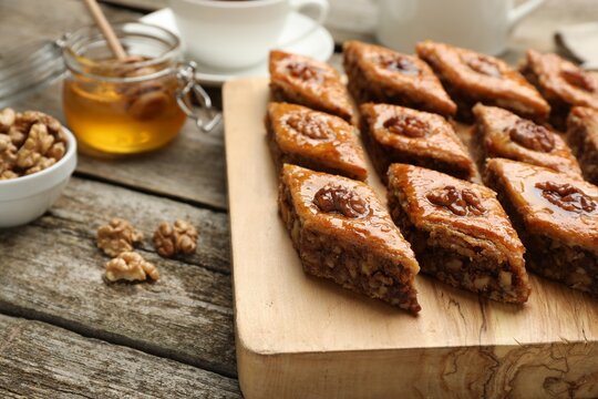 Delicious sweet baklava with walnuts on wooden table, closeup. Space for text