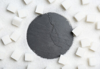 Frame of sugar on black table, flat lay. Space for text