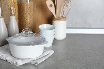 Set of different cooking utensils on grey countertop in kitchen. Space for text