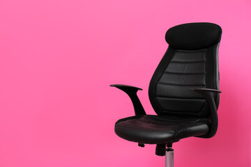 Comfortable office chair on pink background, space for text