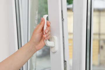 Woman opening white plastic window at home, closeup