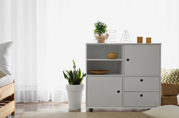 Chest of drawers in stylish room interior