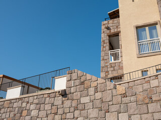 Fototapeta na wymiar building facade with stone wall in front of sky background