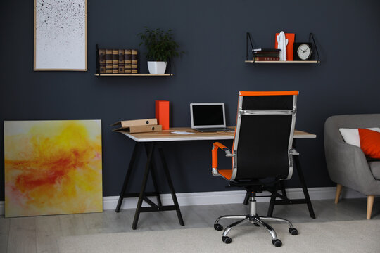 Modern workplace with comfortable chair in stylish home office interior