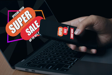Young man using smartphone and laptop shopping online with screen super sale discount banner...