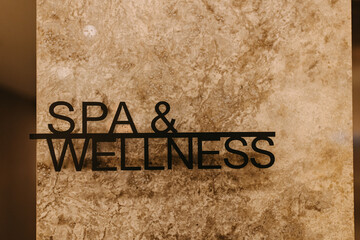 spa and wellness text in steel on a marble wall