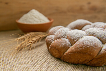 bread with wheat and grains on wooden background