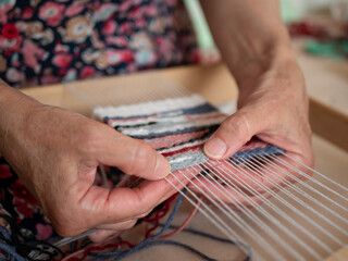 Artisan weaver is at work on the hand loom. Tapestry weaving, selective focus. Work process of artisan