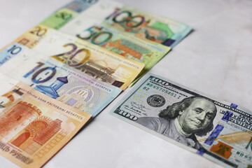 Banknotes in denominations of 100,50,20,10.5 belarusian rubles and 100 dollars on an grey background