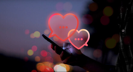illustrated red speech bubbles shaped as a heart above a hand holding a smartphone with screen...