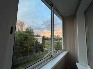 view from the apartment window of the sunset in the city