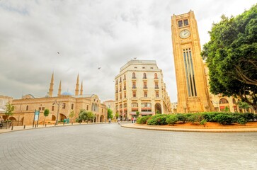 The clock tower in Nejme Square in Beirut, Lebanon, some local architecture of downtown Beirut, the Mohammad Al-Amin mosque and Greek orthodox church of St George. - obrazy, fototapety, plakaty