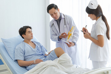 Orthopedic professional doctor and nurse interact with patient who lie on bed , Knee pain patient get treatment advice doctor in examination room.