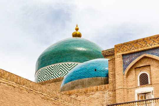 Azure blue and green domes of an old mosque and madrassa in the khanate of Khiva, Uzbekistan, Central Asia
