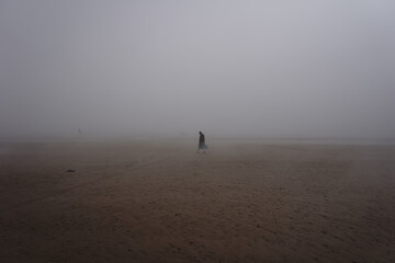 women walking in the mist on the beach