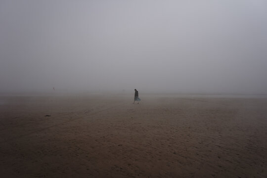 women walking in the mist on the beach