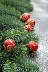 Christmas garland composed of fresh fir branches and red ball ornaments