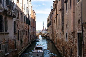 Obraz na płótnie Canvas View of a narrow canal and boat and ancient buildings at Venice, Veneto, Italy.