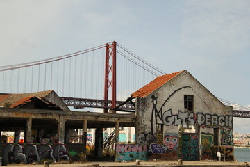 Bridge "Ponte 25 de Abril" in Lisbon with ruins in front