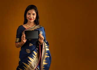 Young beautiful girl showing a blank screen of smartphone or mobile or tablet phone