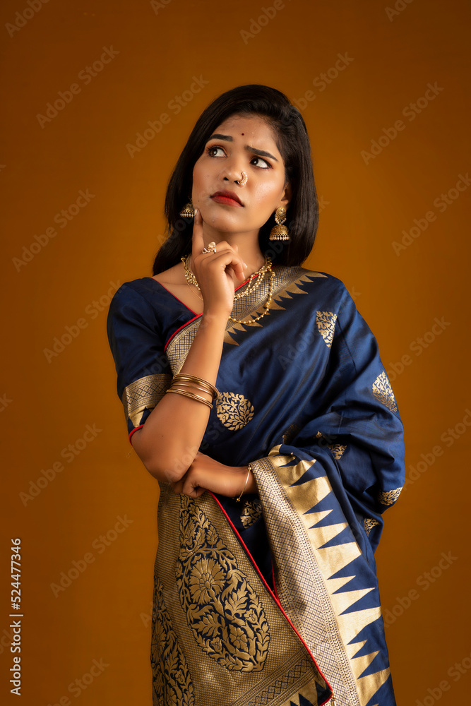 Wall mural portrait of a young girl or woman thinking on a brown background