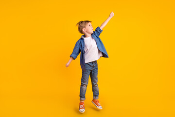Full body portrait of carefree crazy person jump raise arm hold empty space isolated on yellow color background