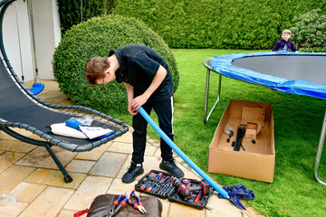 Disassembled trampoline in the yard after purchase. Assembly and installation in a private yard on...