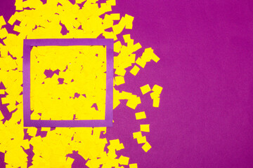 yellow shredded paper with purple frame on purple background, creative art modern design, copy space

