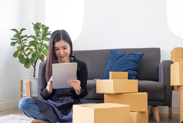 Portrait of Asian young woman SME working with a box at home the workplace.start-up small business owner, small business entrepreneur SME or freelance business online and delivery concept.