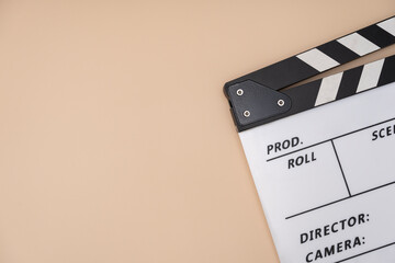 Naklejka premium movie clapper on yellow table background ; film, cinema and video photography concept