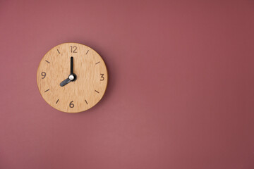 Retro alarm clock on crimson table background, vintage style, flat lay