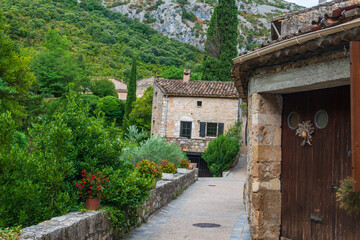 Vieilles maisons au c&oelig;ur du village m&eacute;di&eacute;val de Saint Guilhem le d&eacute;sert  avec la nature autour dans l'H&eacute;rault par une journ&eacute;e nuageuse
