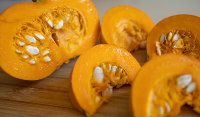 pumpkin slices on a wooden board, in the kitchen. Seasonal vegetables, rich harvest, sliced pumpkin. Diet, proper nutrition, healthy vegetables, vitamins all year round, harvest