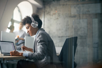 African American businesswoman using smart phone during lunch break in office.