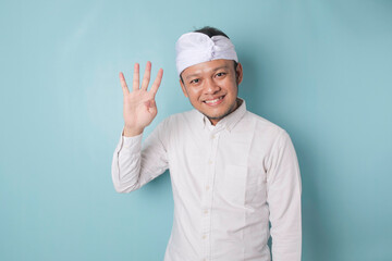 Excited Balinese man wearing udeng or traditional headband and white shirt giving number 12345 by hand gesture