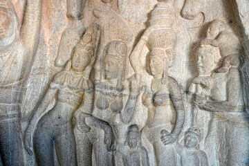 Human rock relief sculptures carved in the rock cut ancient cave temple in Mahabalipuram, Tamilnadu. Indian rock art of bas relief human sculptures at rock cut historical monolithic cave in Tamilnadu.