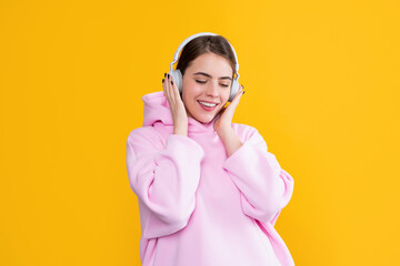 happy girl listen music in headphones on yellow background