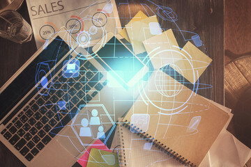 Social network hologram drawings over computer on the desktop background. Top view. Double exposure.