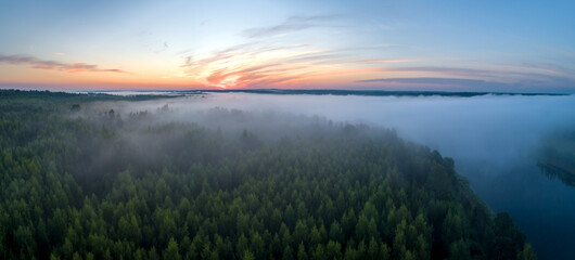 Fototapeta na wymiar Summer dawn over foggy forest and river aerial drone view. Aerial panoramic landscape with sunset over the river and beautiful clouds on the sky.