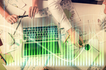 Double exposure of man and woman working together and financial graph hologram. Business concept. Computer background.